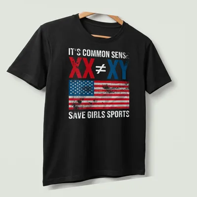 Distressed vintage T-shirt with American flag and bold text on saving girls sports. — printed on a unisex t-shirt (angled view)