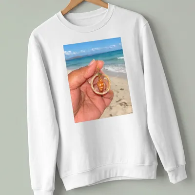 Orange shell jewelry in beach photography style with woven hoops — printed on a unisex sweatshirt