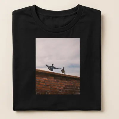 Photographic design of birds perched on a brick wall in natural colors — printed on a women's shirt