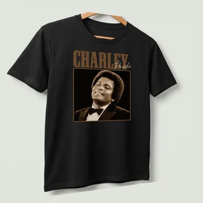 Vintage Charley Pride t-shirt featuring bold typography in brown and beige — printed on a unisex t-shirt (angled view)