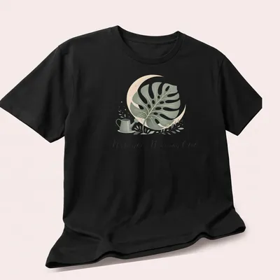 Midnight Watering Club shirt with a monstera leaf illustration in botanical style — printed on a unisex t-shirt (angled view)