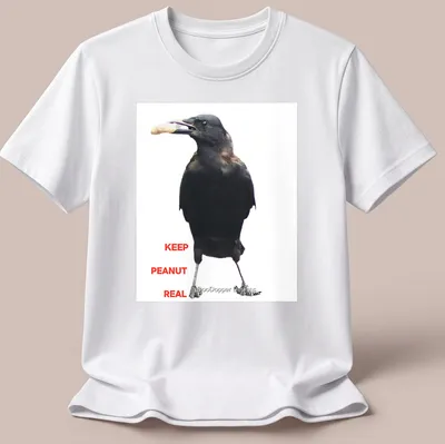 A photographic crow design with the text 'KEEP PEANUT REAL' in black and white. — printed on a unisex t-shirt