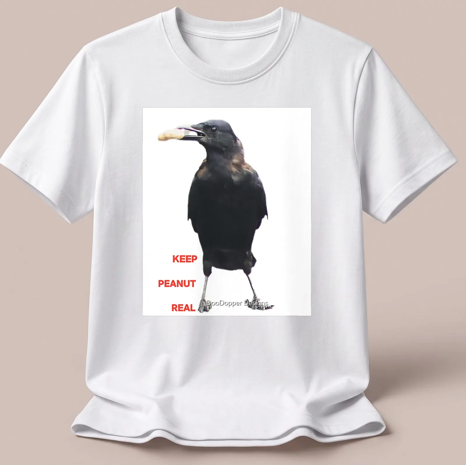 A photographic crow design with the text 'KEEP PEANUT REAL' in black and white. — printed on a unisex t-shirt