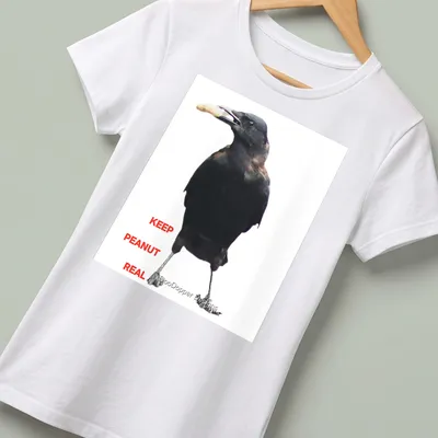 A photographic crow design with the text 'KEEP PEANUT REAL' in black and white. — printed on a women's shirt