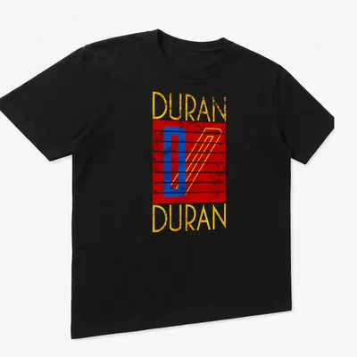 Retro distressed Duran Duran logo t-shirt in red, blue, yellow, and white — printed on a unisex t-shirt (angled view)