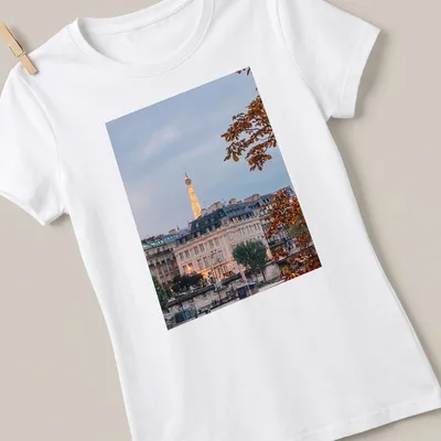 Photographic print of the Eiffel Tower with a Paris cityscape in gray, gold, green, and brown — printed on a women's shirt