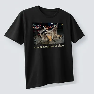Photorealistic raccoon holding a coffee cup with the phrase 'somebody's feral Aunt' above it. — printed on a unisex t-shirt (angled view)