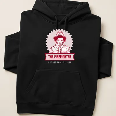Bold illustration of a firefighter with text 'THE FIREFIGHTER' in red and light pink — printed on a unisex hoodie