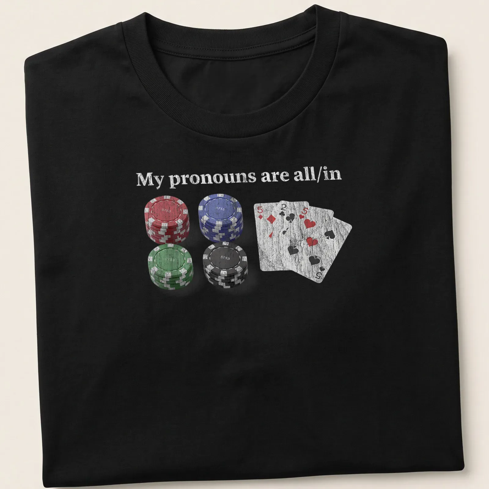 Distressed t-shirt featuring poker chips and cards with the text 'My pronouns are all/in.' — printed on a unisex t-shirt