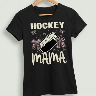 Illustration of a hockey puck with bows and text 'Hockey Mama' in playful style — printed on a women's shirt