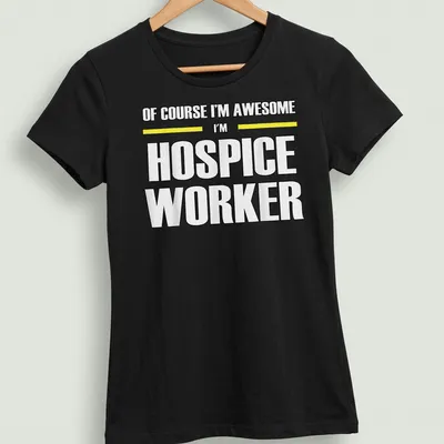 Bold typography shirt reading 'Of Course I’m Awesome I’m Hospice Worker' in black, yellow, and white — printed on a women's shirt