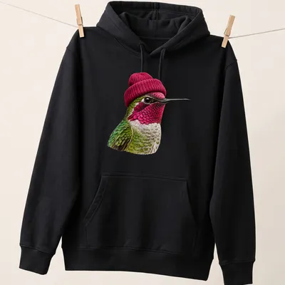 Realistic hummingbird wearing a beanie in green, pink, and white — printed on a unisex hoodie