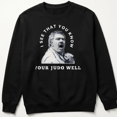Stylized portrait of a passionate judo coach with motivational text — printed on a unisex sweatshirt