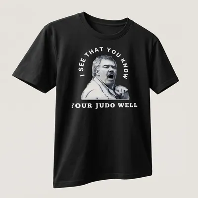 Stylized portrait of a passionate judo coach with motivational text — printed on a unisex t-shirt (angled view)