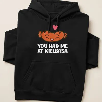 Kawaii t-shirt featuring a smiling kielbasa with playful text above. — printed on a unisex hoodie