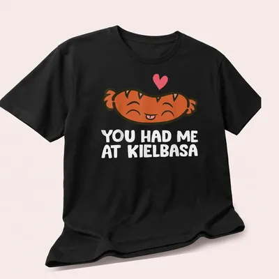 Kawaii t-shirt featuring a smiling kielbasa with playful text above. — printed on a unisex t-shirt (angled view)