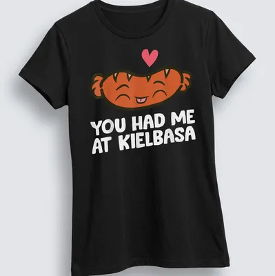 Kawaii t-shirt featuring a smiling kielbasa with playful text above. — printed on a women's shirt