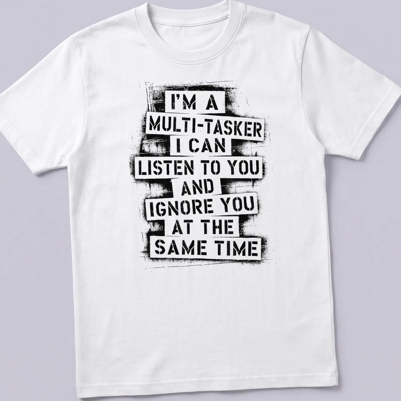 Bold typographic tee displaying humorous multitasking phrase in black and white — printed on a unisex t-shirt