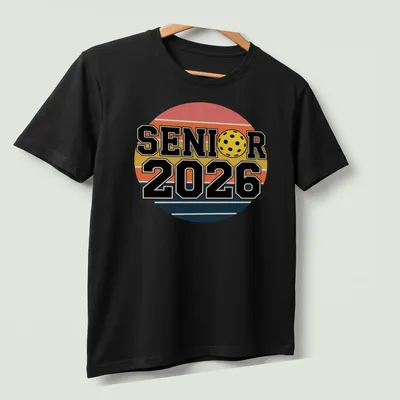 Retro pickleball graduation shirt with bold text and colorful graphics — printed on a unisex t-shirt (angled view)