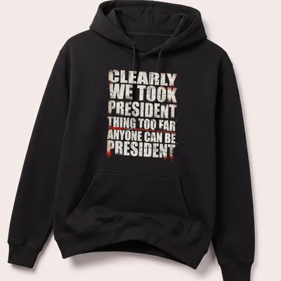 Grunge-style political humor t-shirt with bold text in red, white, and black — printed on a unisex hoodie
