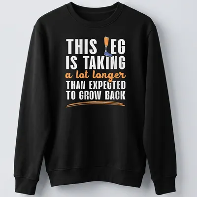 Playful cartoon t-shirt featuring a prosthetic leg humorously remarking on recovery time — printed on a unisex sweatshirt