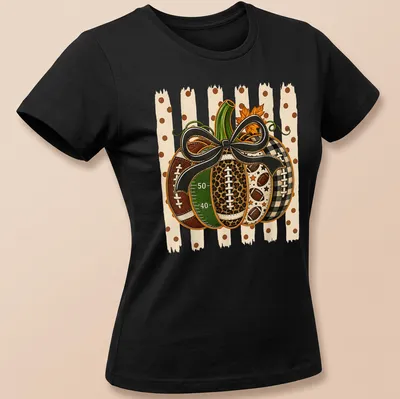 Colorful illustration of a pumpkin with footballs and bow in autumn hues — printed on a women's shirt