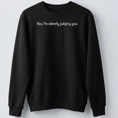 White t-shirt with a playful print stating 'Yes, I'm silently judging you.' — printed on a unisex sweatshirt