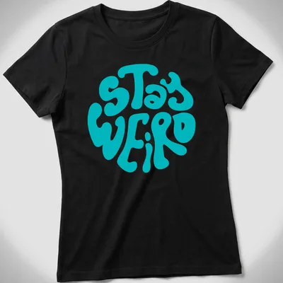 Round design t-shirt with bold 'Stay Weird' text in playful typography — printed on a women's shirt