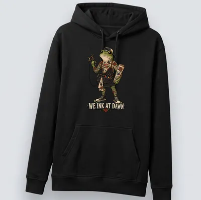 Vintage tattoo style t-shirt featuring a frog with the text We Ink At Dawn. — printed on a unisex hoodie