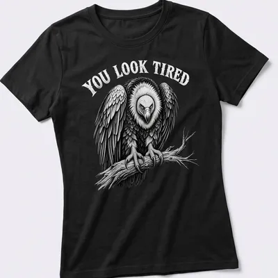 Vulture graphic with the text 'YOU LOOK TIRED' in retro font — printed on a women's shirt