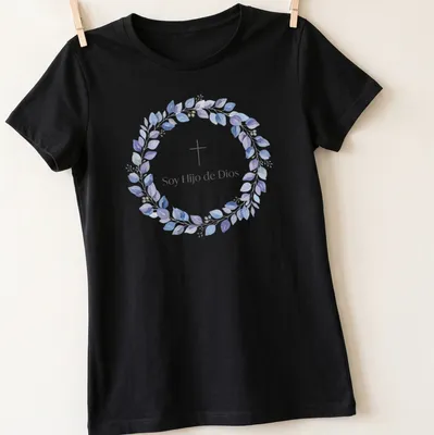 Watercolor design featuring cross and leaves with text 'Soy Hijo de Dios' in purple, blue, green, and white — printed on a women's shirt