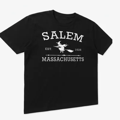 Vintage-style graphic of a witch with text 'Salem Massachusetts Est 1626' in white — printed on a unisex t-shirt (angled view)