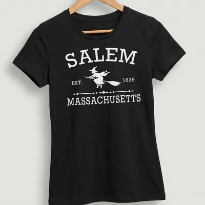 Vintage-style graphic of a witch with text 'Salem Massachusetts Est 1626' in white — printed on a women's shirt